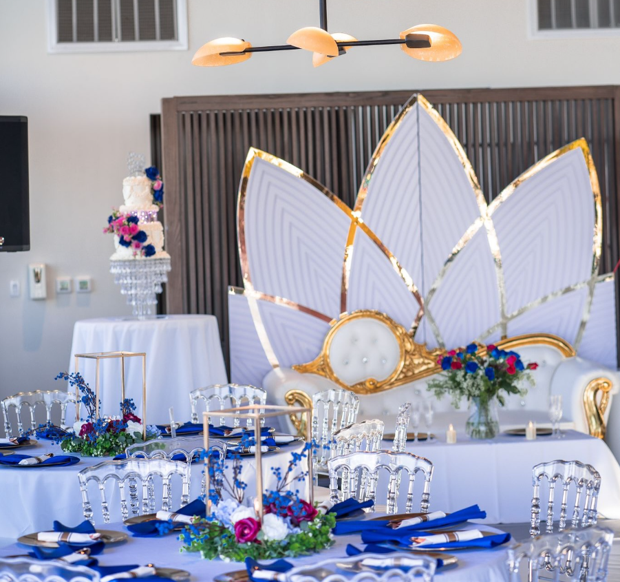 A room with tables and chairs set up for a wedding reception