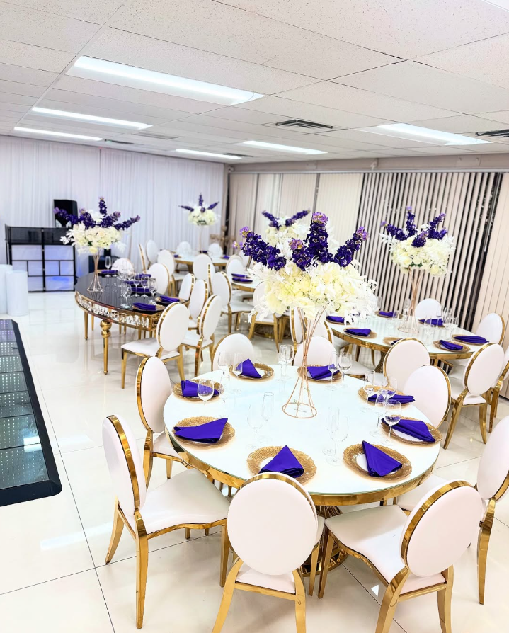 A large room with tables and chairs set up for a wedding reception.