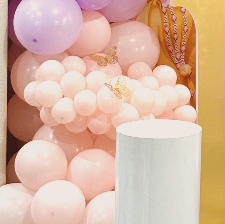 A bunch of pink and purple balloons with a butterfly on them