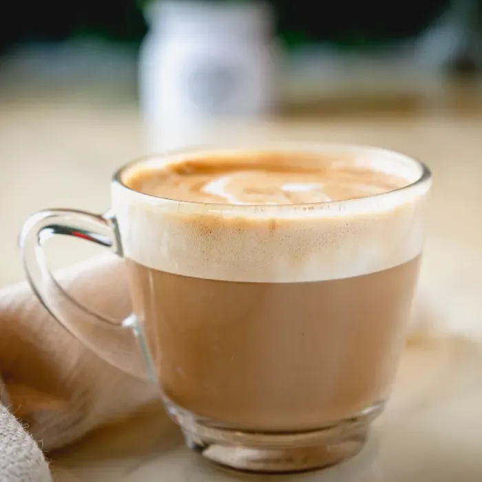 A close up of a cup of coffee on a table.