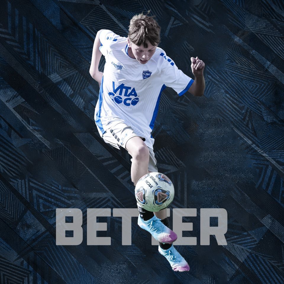 A soccer player in a white jersey with blue accents juggles a soccer ball in front of a dark, geometric patterned background.