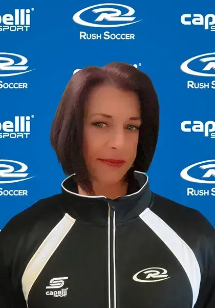 Woman wearing a black and white track jacket, with a Rush Soccer background.