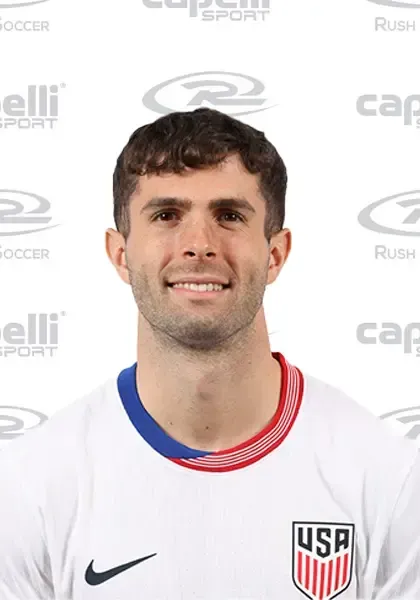 Christian Pulisic wearing the USA soccer uniform, smiling at the camera.