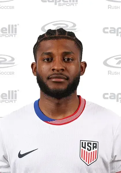 Mark Mckenzie in a white jersey with USA emblem, looking forward.