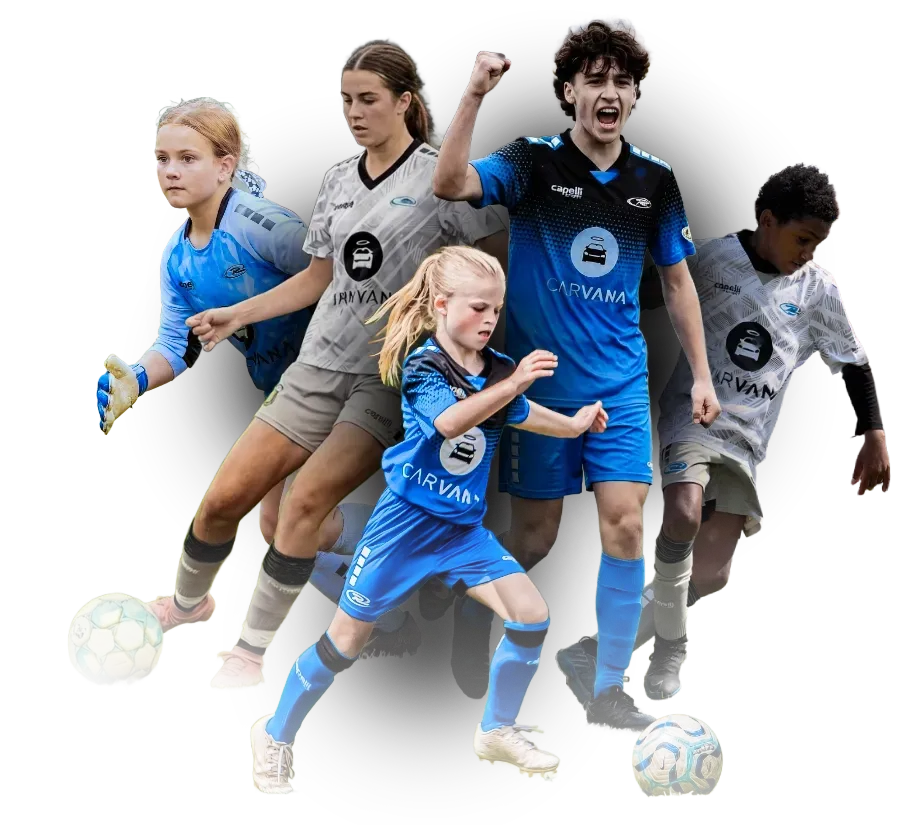 Woman in blue soccer jersey, holding up jersey, with other soccer players in background.