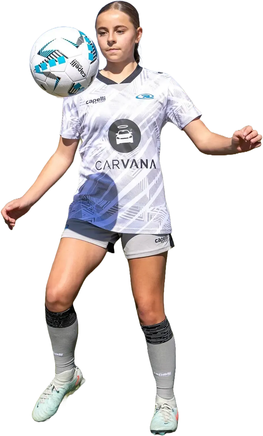 Soccer player in white jersey, using her head to control a ball. Outdoors, sunny day.