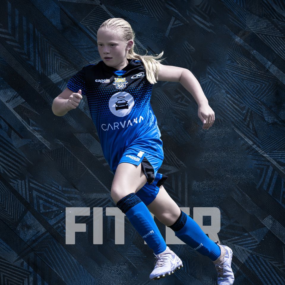 A soccer player in a black and blue striped jersey and blue shorts sprints against a patterned, dark gray background.