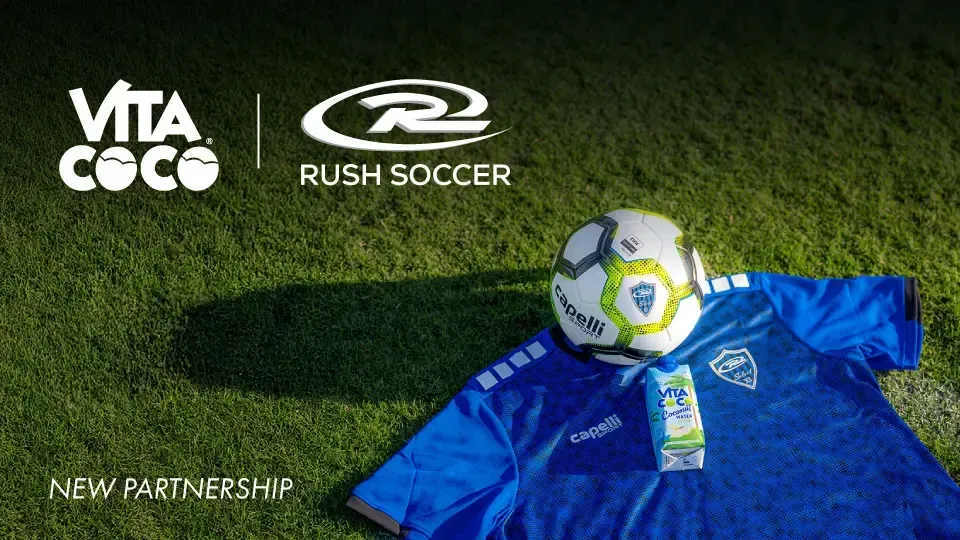Vita Coco logo and Rush Soccer logo with soccer ball and blue jersey on grass field.