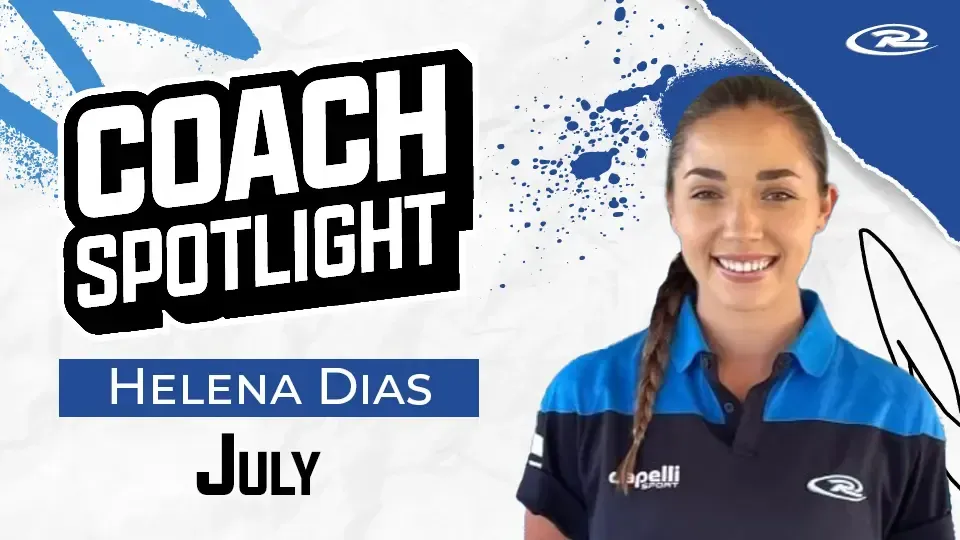 A woman is wearing a blue and black polo shirt and smiling.