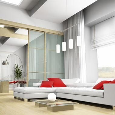 Una sala de estar con un sofá seccional blanco y almohadas rojas.