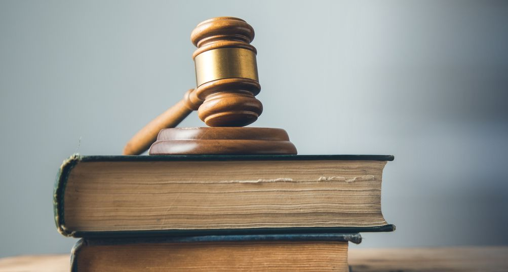 Maillet en bois posé sur deux livres de droit.