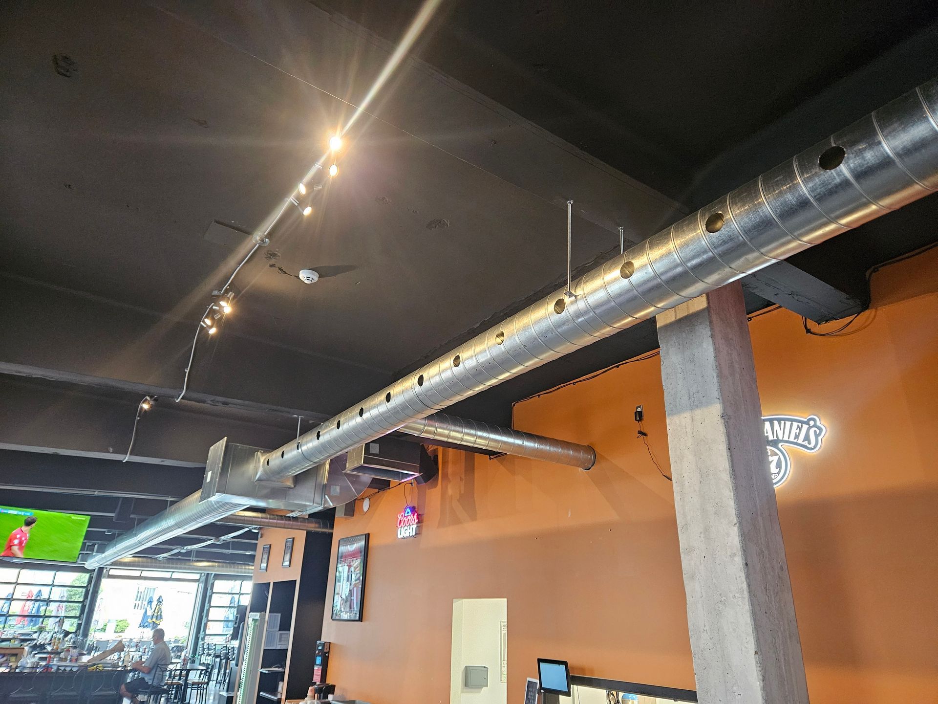 Un restaurant avec beaucoup de tuyaux suspendus au plafond