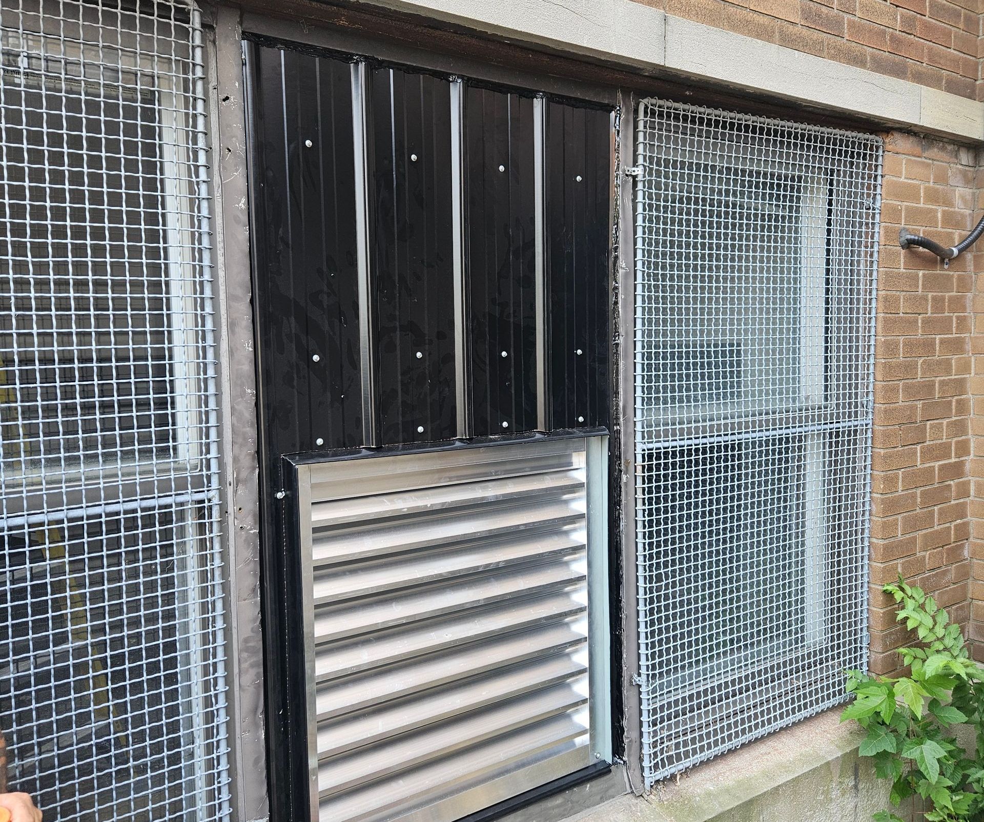 A brick building with a metal gate and a window