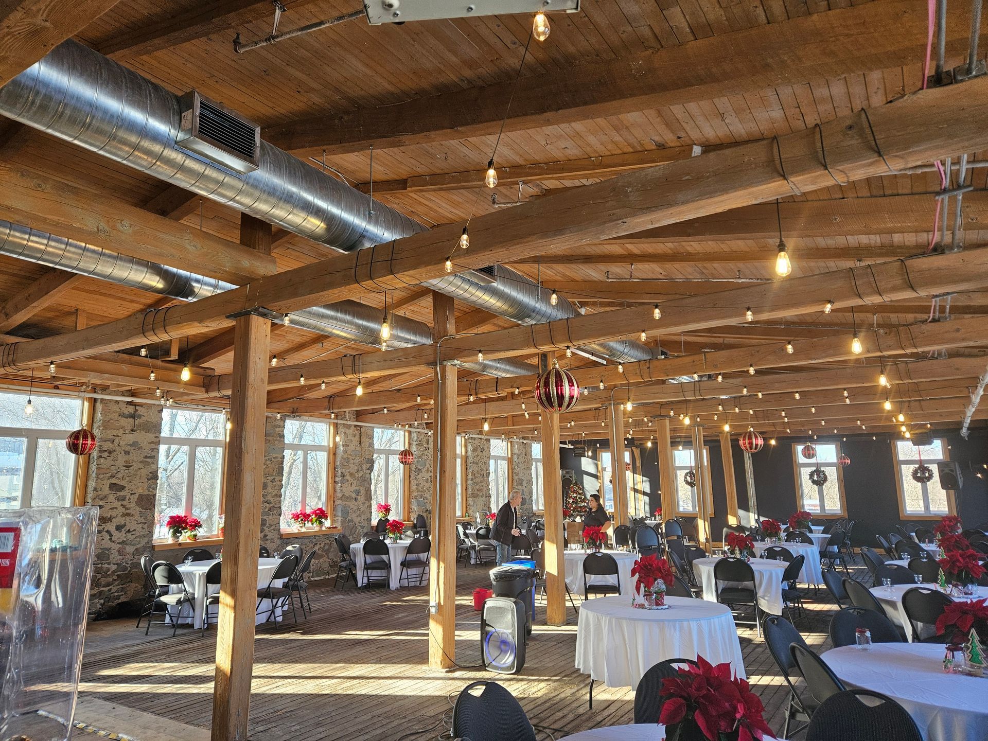 A large room with tables and chairs set up for a wedding reception.