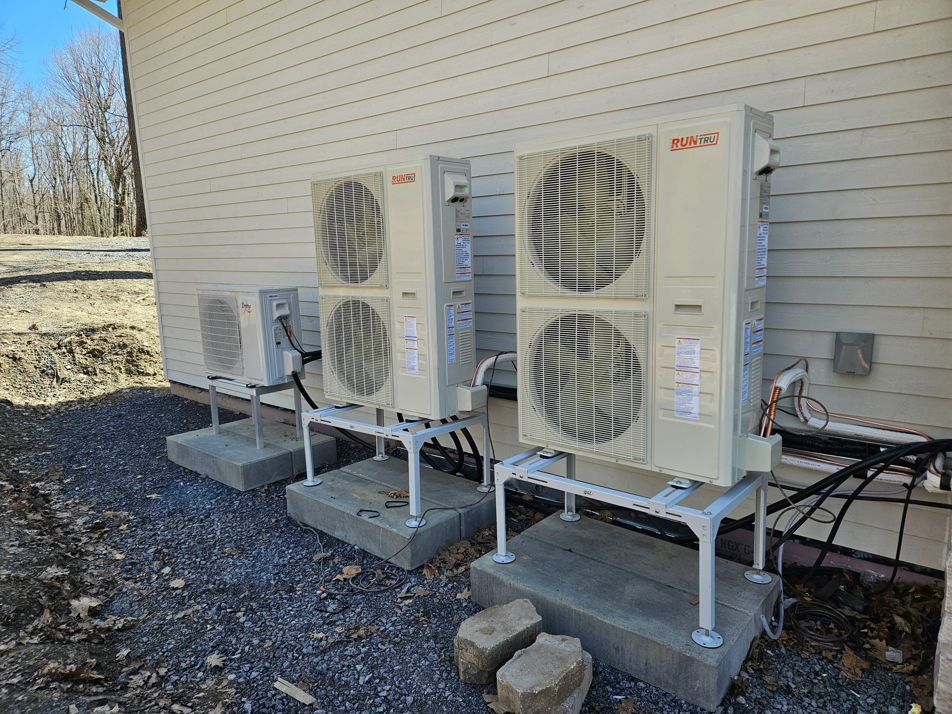 A row of air conditioners are sitting outside of a building.