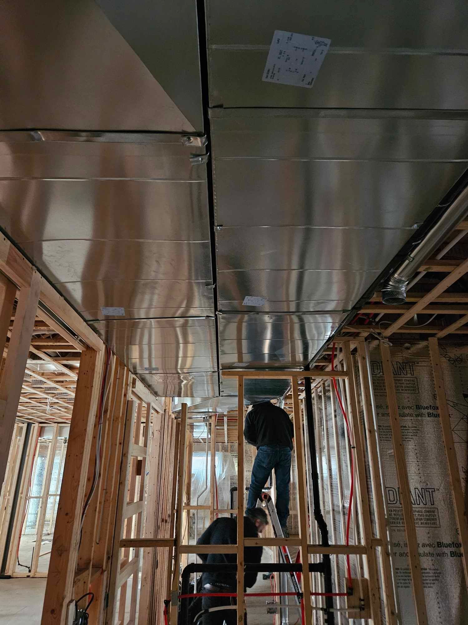 Un homme se tient debout sur une échelle dans un bâtiment en construction.