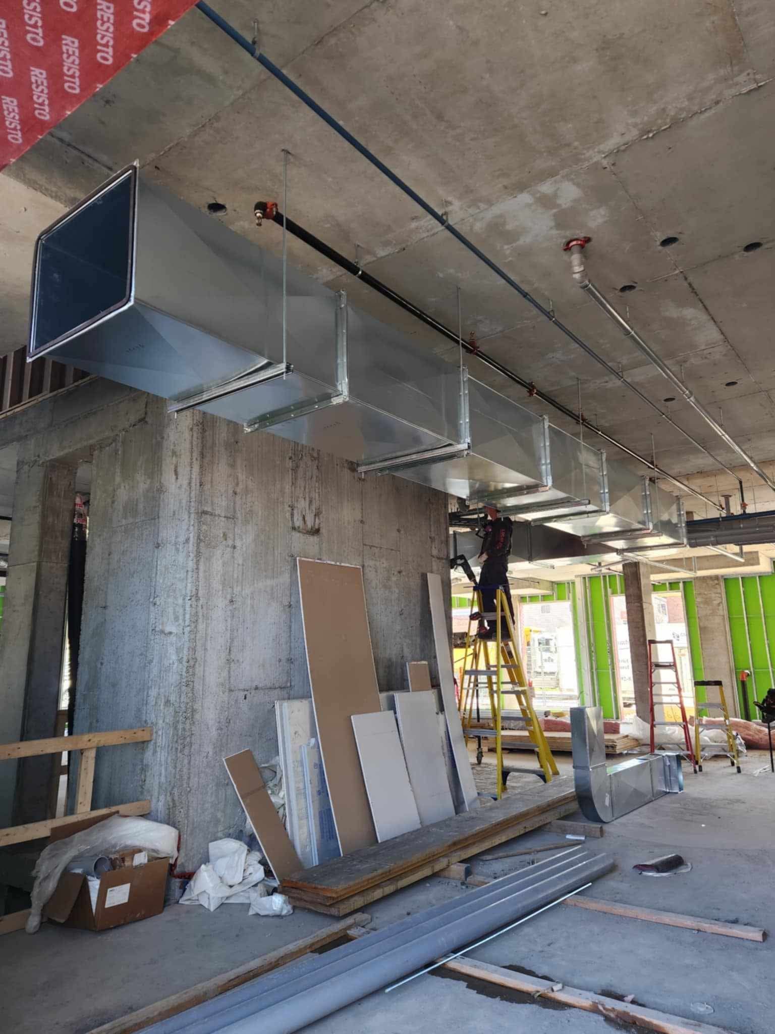 Un homme se tient debout sur une échelle dans un bâtiment en construction.