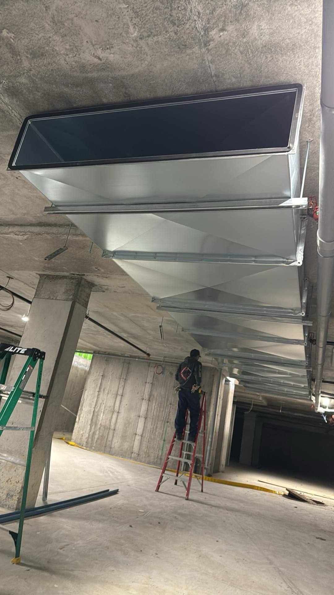 Un homme se tient debout sur une échelle dans un bâtiment.