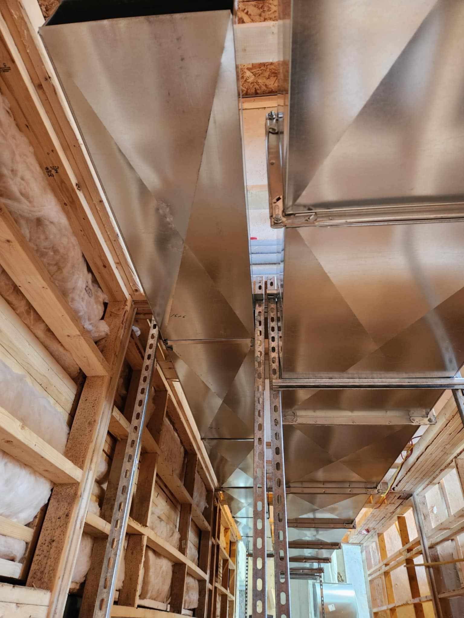 Un entrepôt avec beaucoup d'étagères en bois et de tuyaux en métal.