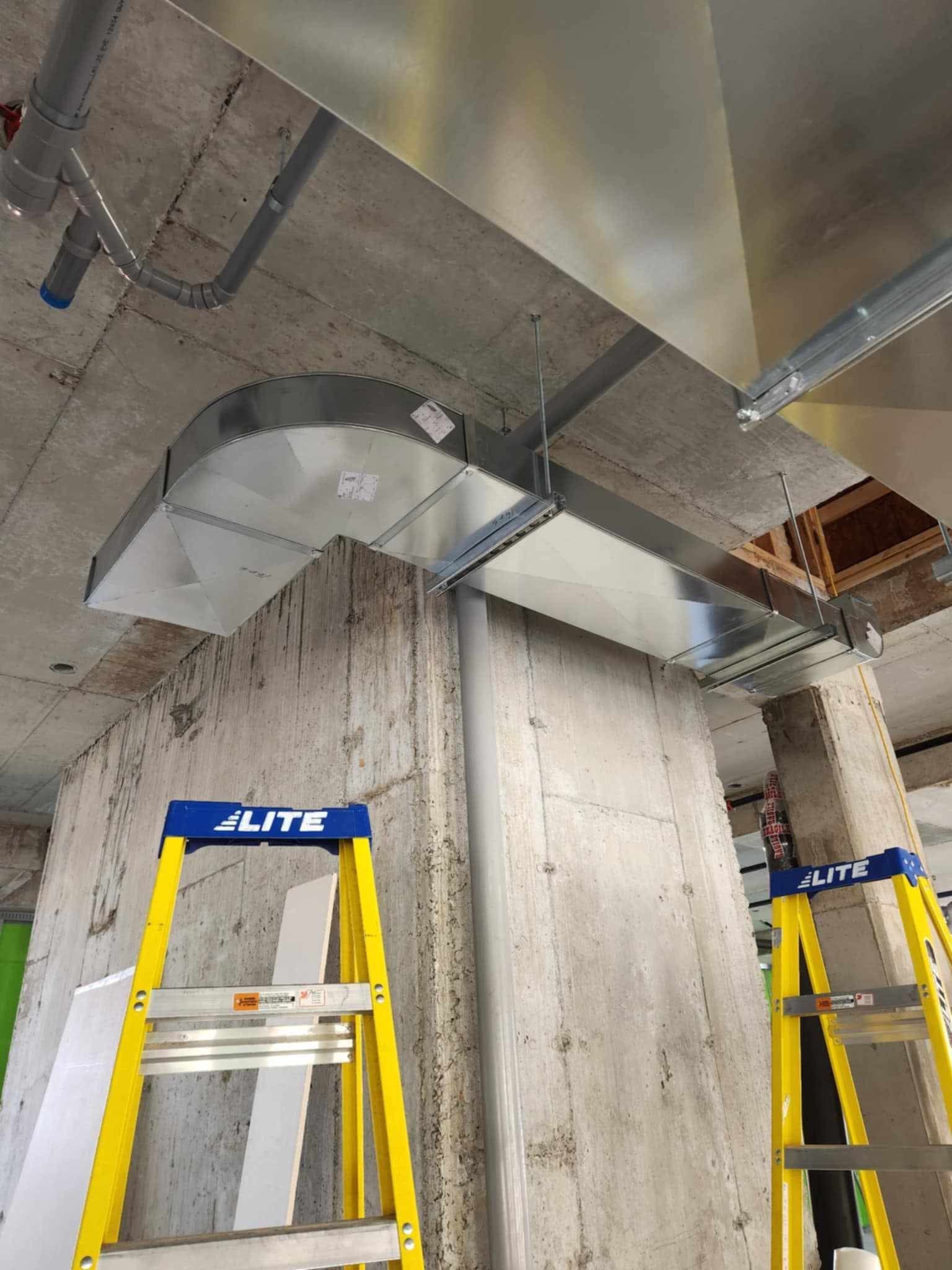 Deux échelles sont posées l'une à côté de l'autre sur un mur en béton.