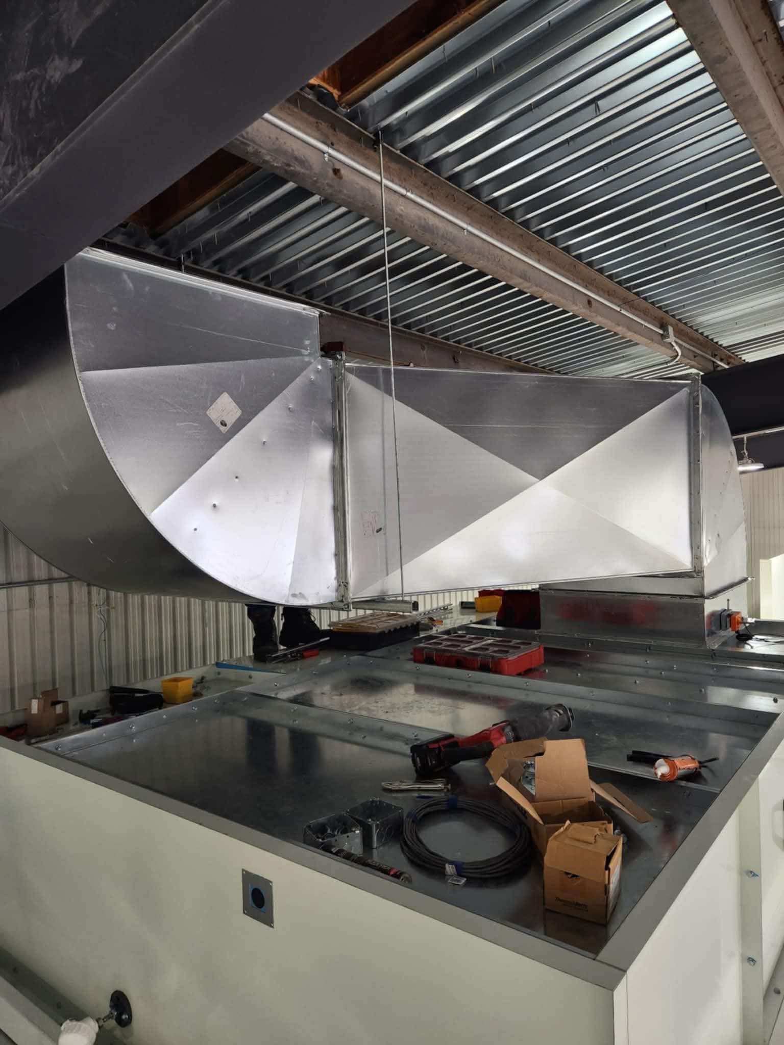 Un gros tuyau métallique est suspendu au plafond d'un bâtiment.