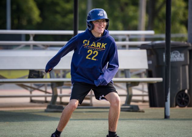 Baseball player sliding into home plate, catcher in front. Blue and gold uniforms, action shot.