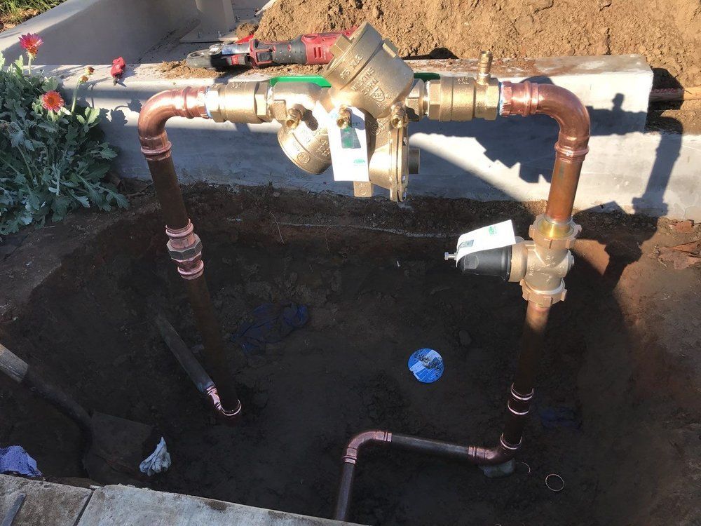 Pride Plumbing, Inc | A bunch of pipes are in a hole in the ground