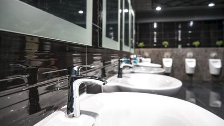 Pride Plumbing, Inc | A row of sinks and urinals in a public restroom.