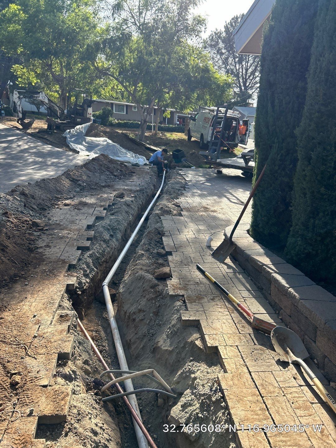 Pride Plumbing, Inc | A pipe is being installed in the ground next to a house.