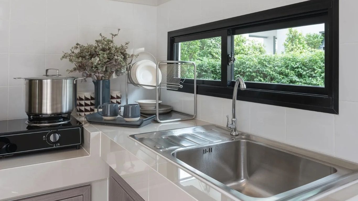 Pride Plumbing, Inc | A kitchen with a sink , stove and window.