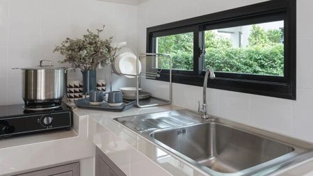 Pride Plumbing, Inc | A kitchen with a sink , stove and window.