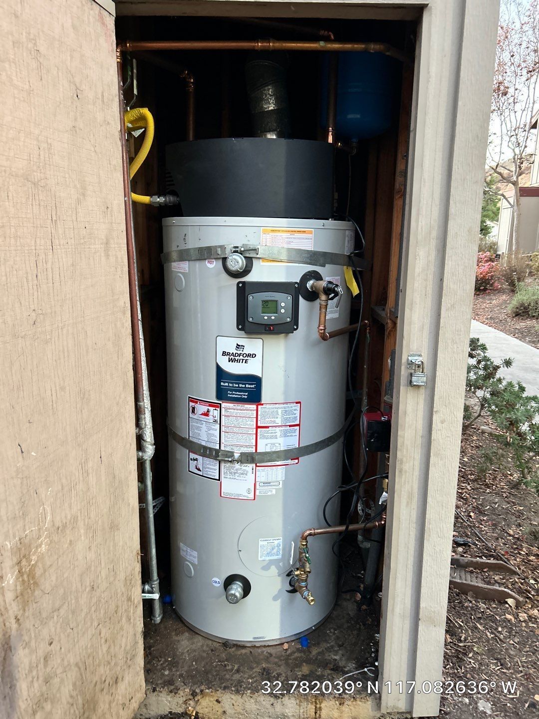 Large residential water heater installed by Pride Plumbing inside utility shed