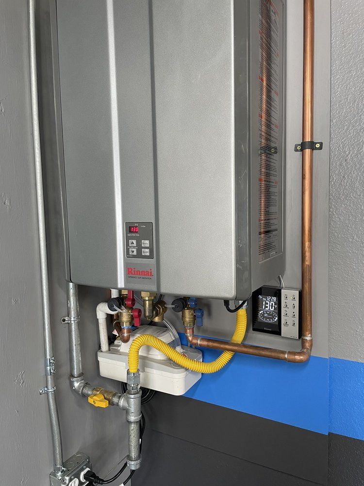 Wall-mounted water heater with copper pipe installation by Pride Plumbing, Inc.