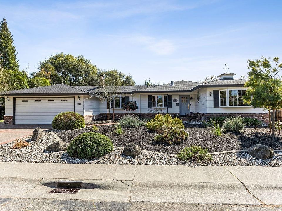 A large white house with a black roof and a white garage door | Sell a Home in Greenhaven-Pocket, Sacramento, CA