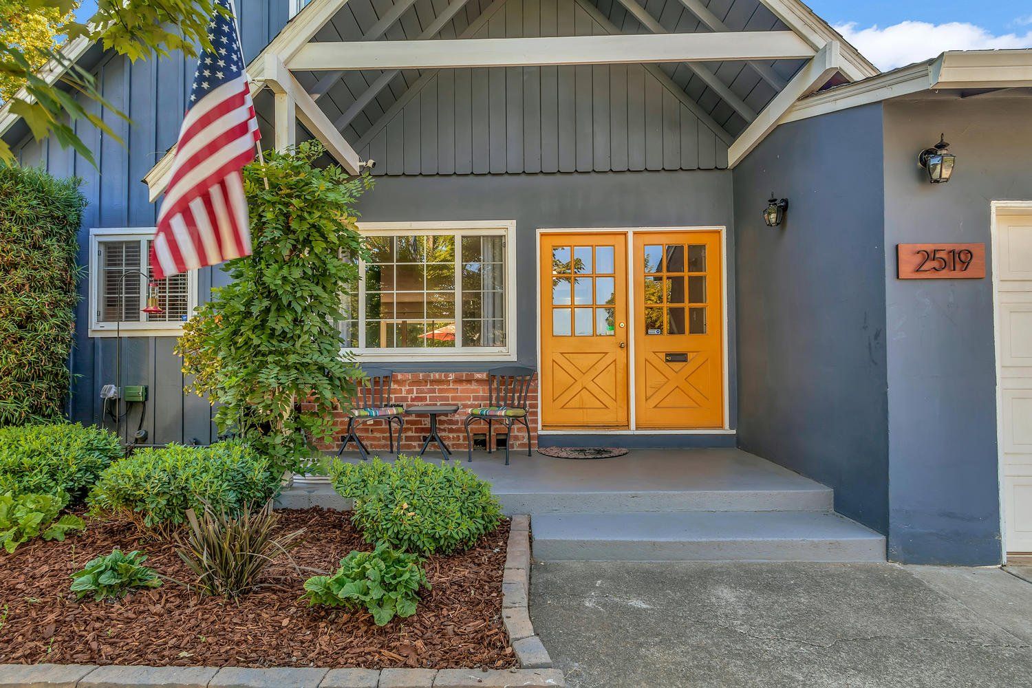 Gray house with an American flag on the porch. Find homes for sale in Greenhaven-Pocket, with Catricala Real Estate Group