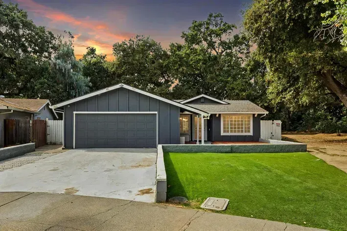 A house with a large garage and a lush green yard | Homes for Sale in Greenhaven-Pocket, Sacramento, CA
