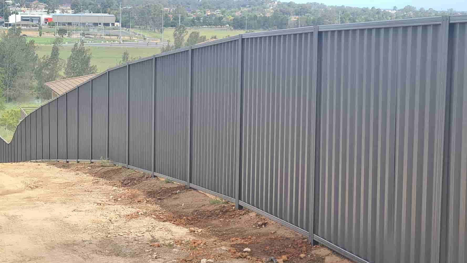 Galvanized Corrugated Metal Fence on a Hillside — A&H Fences In Bowral, NSW