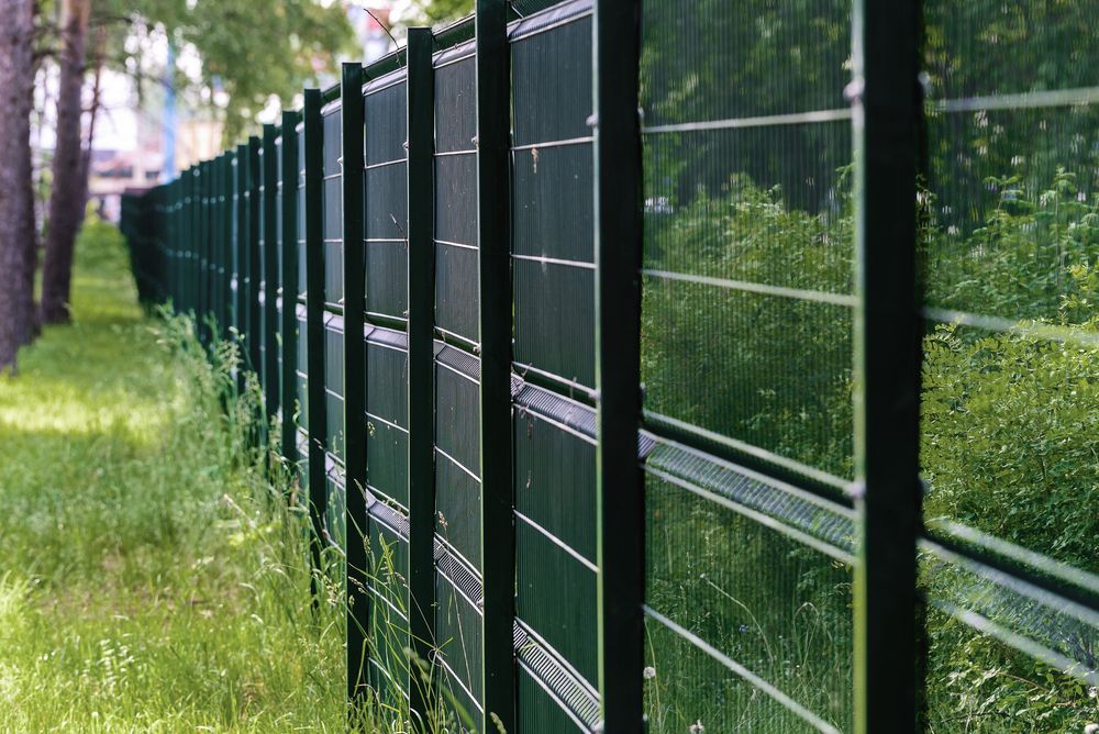 Green Metal Fence in a Grassy Area — A&H Fences In Aylmerton, NSW