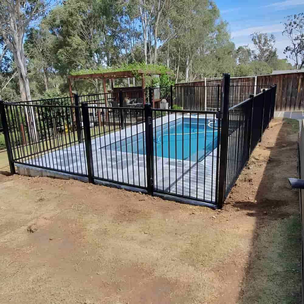 A Large Swimming Pool Surrounded by a Black Metal Fence — A&H Fences In Aylmerton, NSW