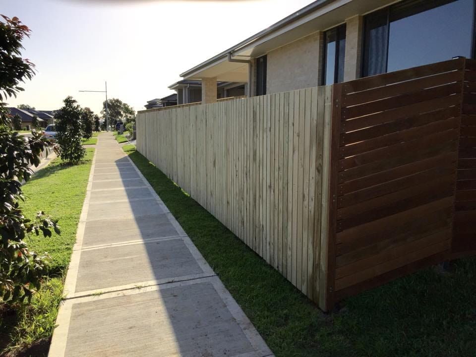 A Wooden Fence Along a Sidewalk Next to a House — A&H Fences In Mittagong, NSW