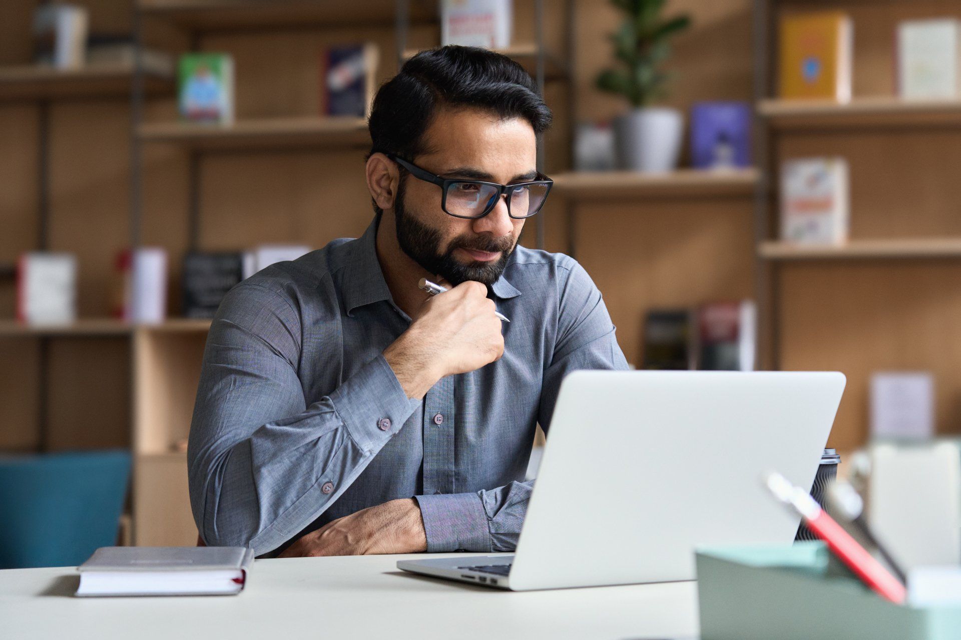 A man is sitting at a desk using a laptop computer.