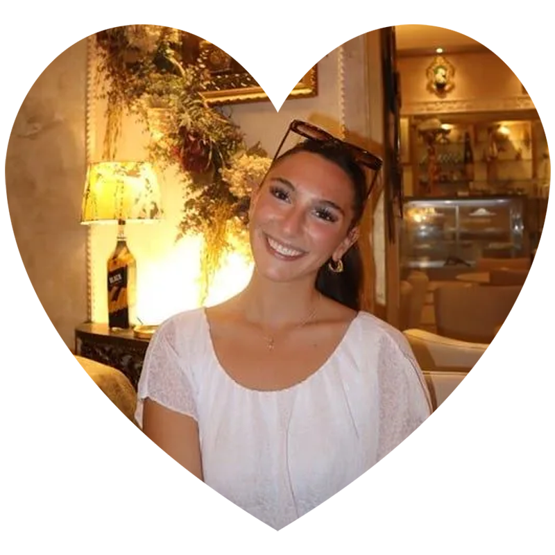 A woman is smiling while sitting at a table in a restaurant