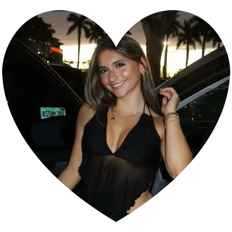 A woman in a black top is standing next to a car