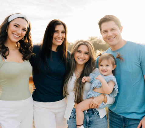 A young boy is holding a bunch of balloons in a living room.