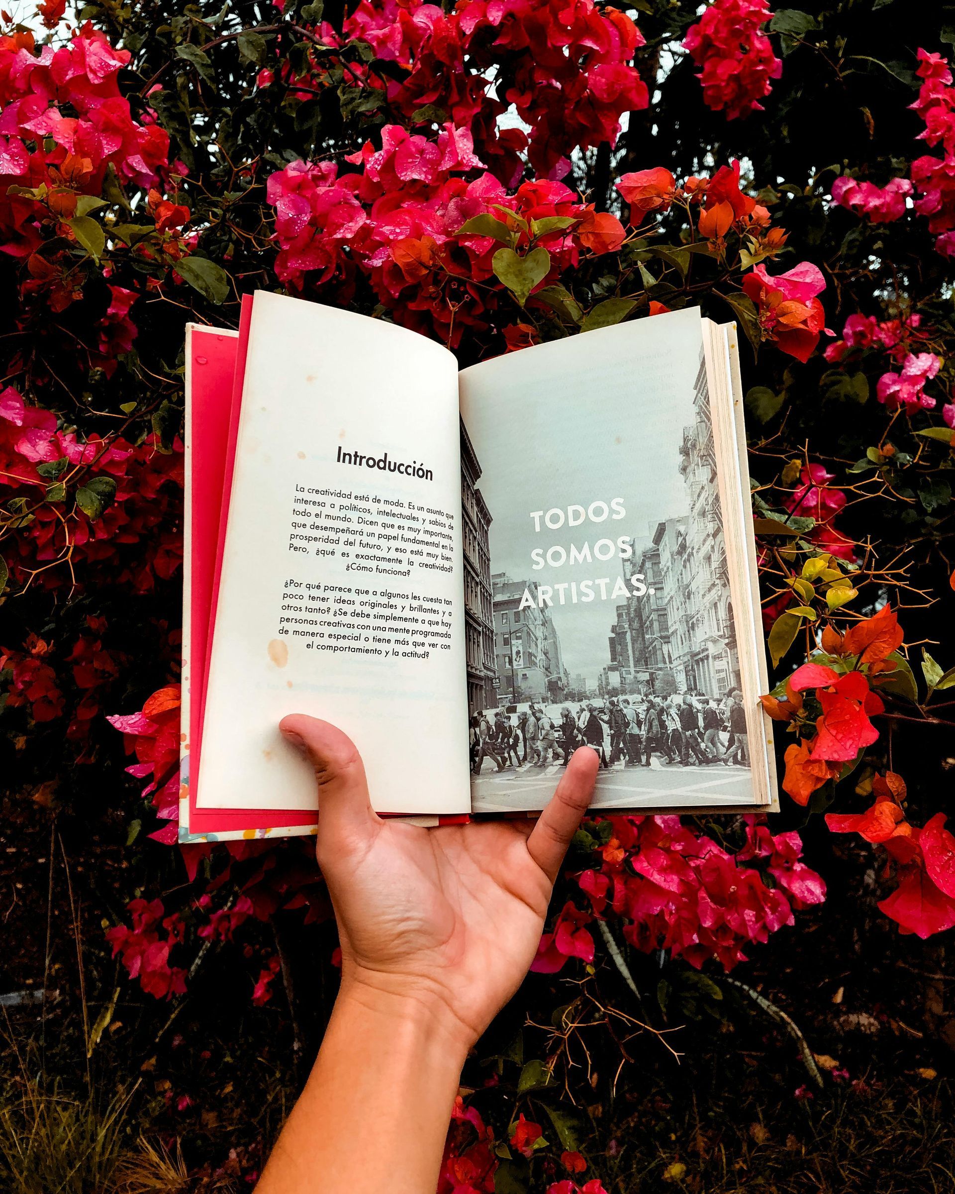 E-reader displaying text next to a stack of physical books on a table; bookshelves in background.