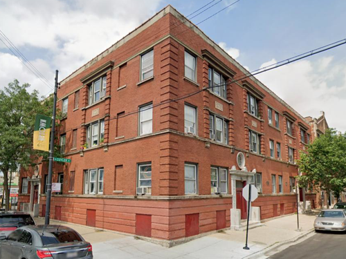 a large red brick building with a lot of windows and a balcony .