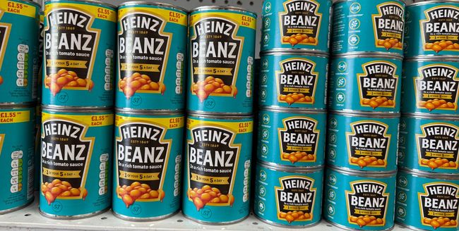 Many cans of heinz beans are stacked on top of each other