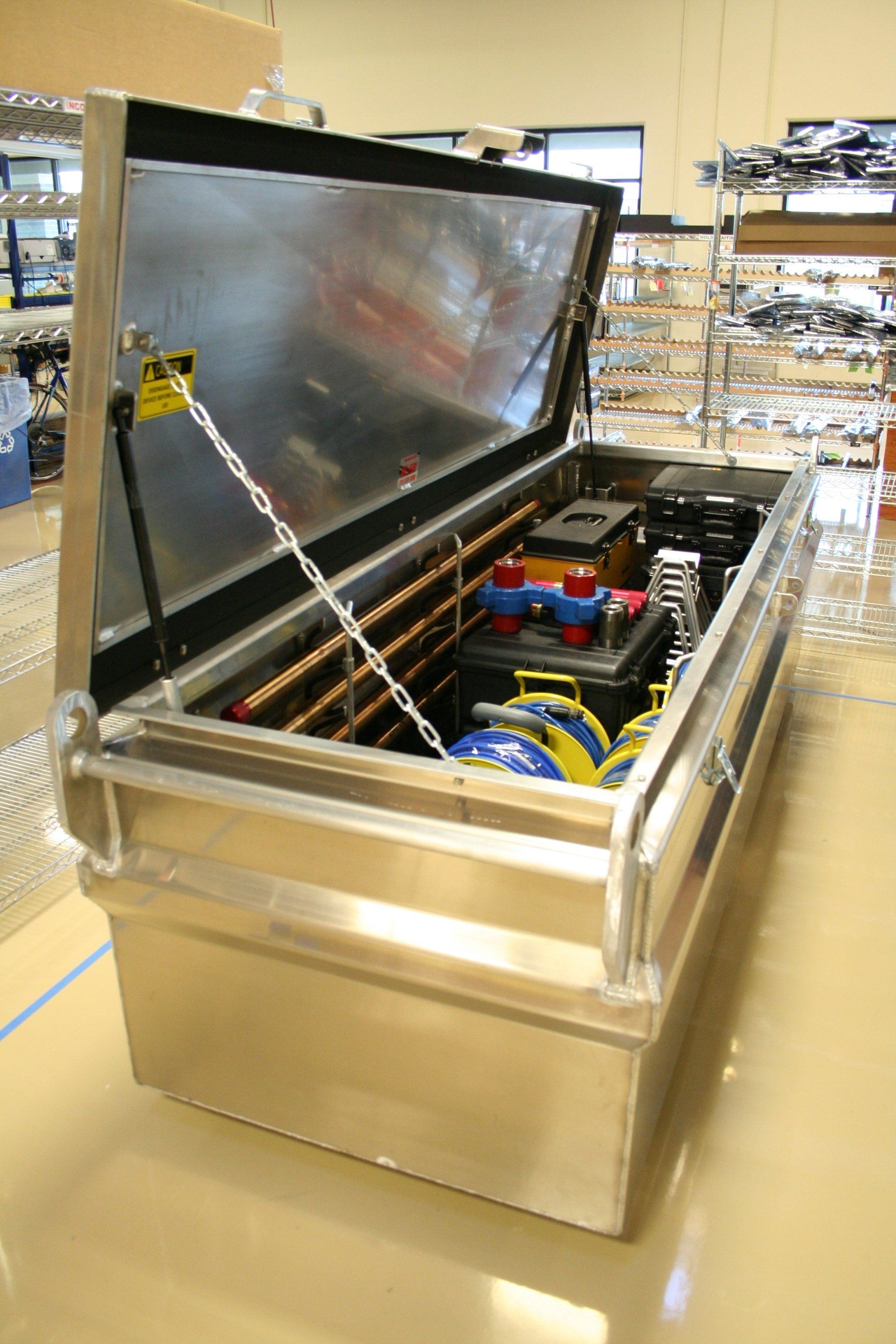 A stainless steel toolbox with the lid open and tools inside of it.