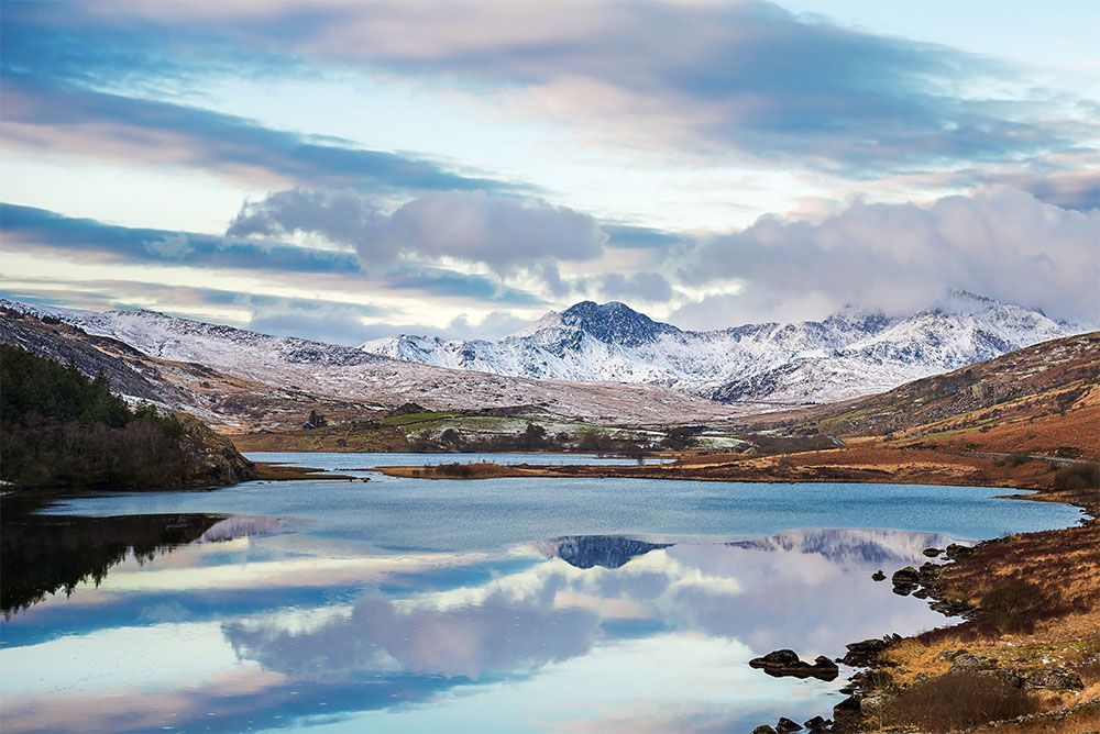 Snow covered mountain range and blue lakes in snowdonia, wales, United Kingdom.