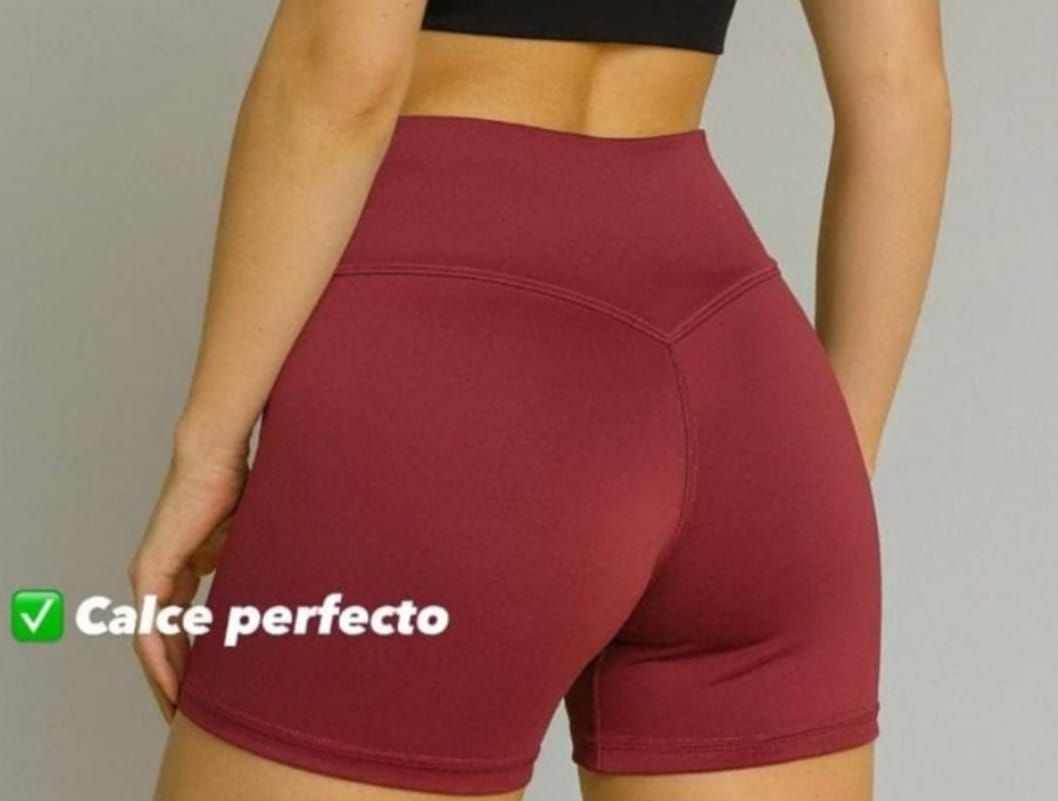 Mujer con sujetador deportivo negro y pantalones cortos burdeos